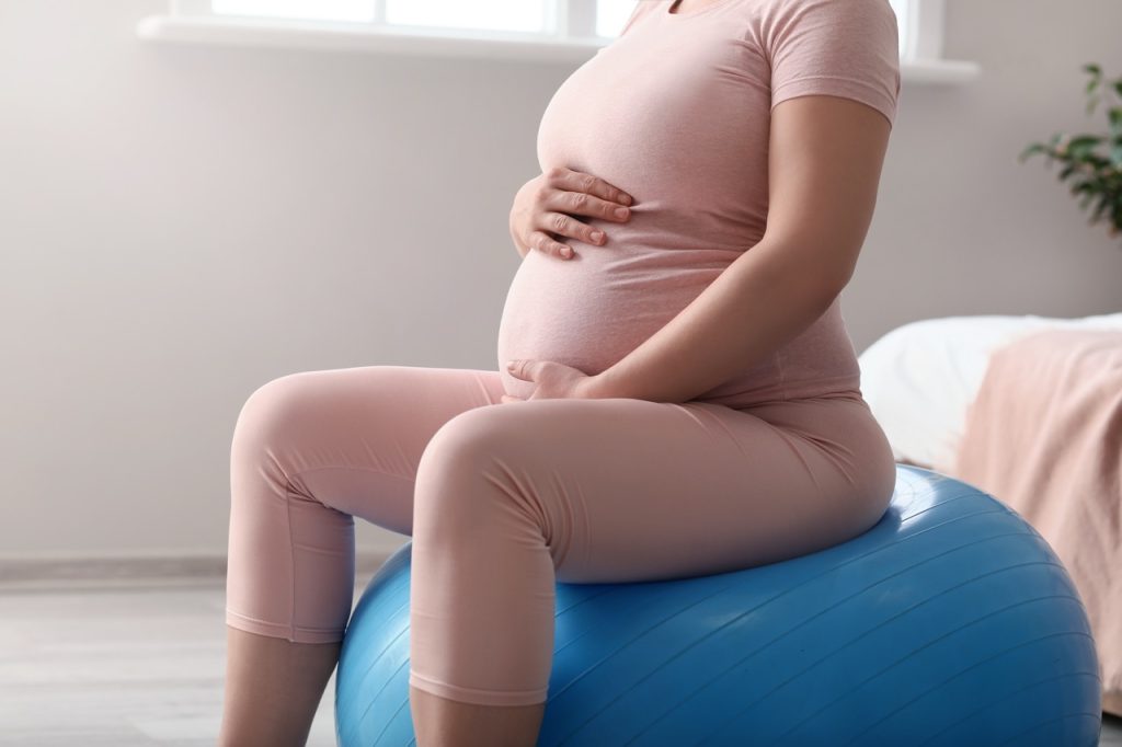 Young pregnant woman training at home
