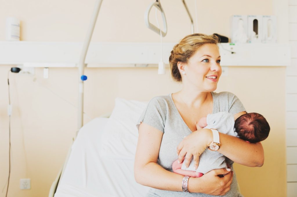 Mother gently cradling her newborn baby shortly after delivery