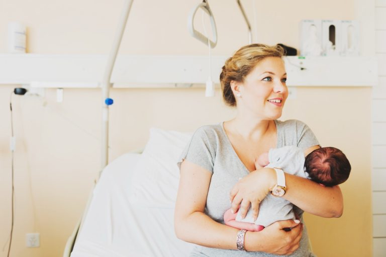 Mother gently cradling her newborn baby shortly after delivery